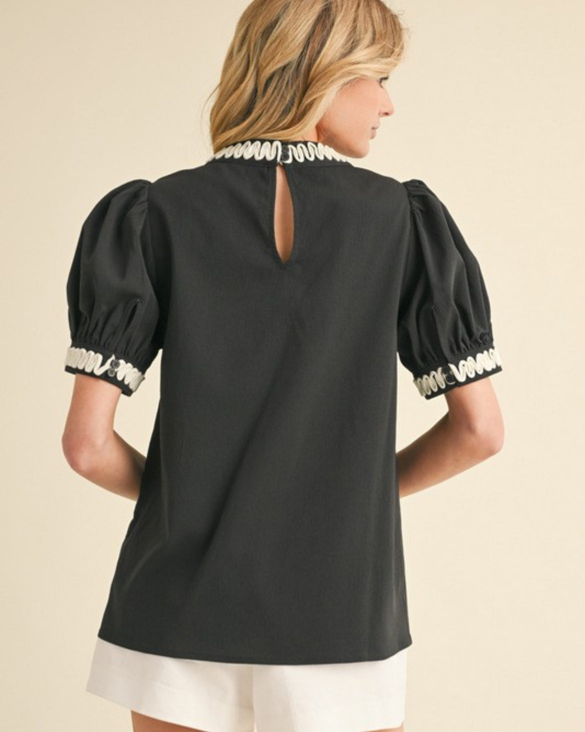 Black top trimmed in white with puff sleeves