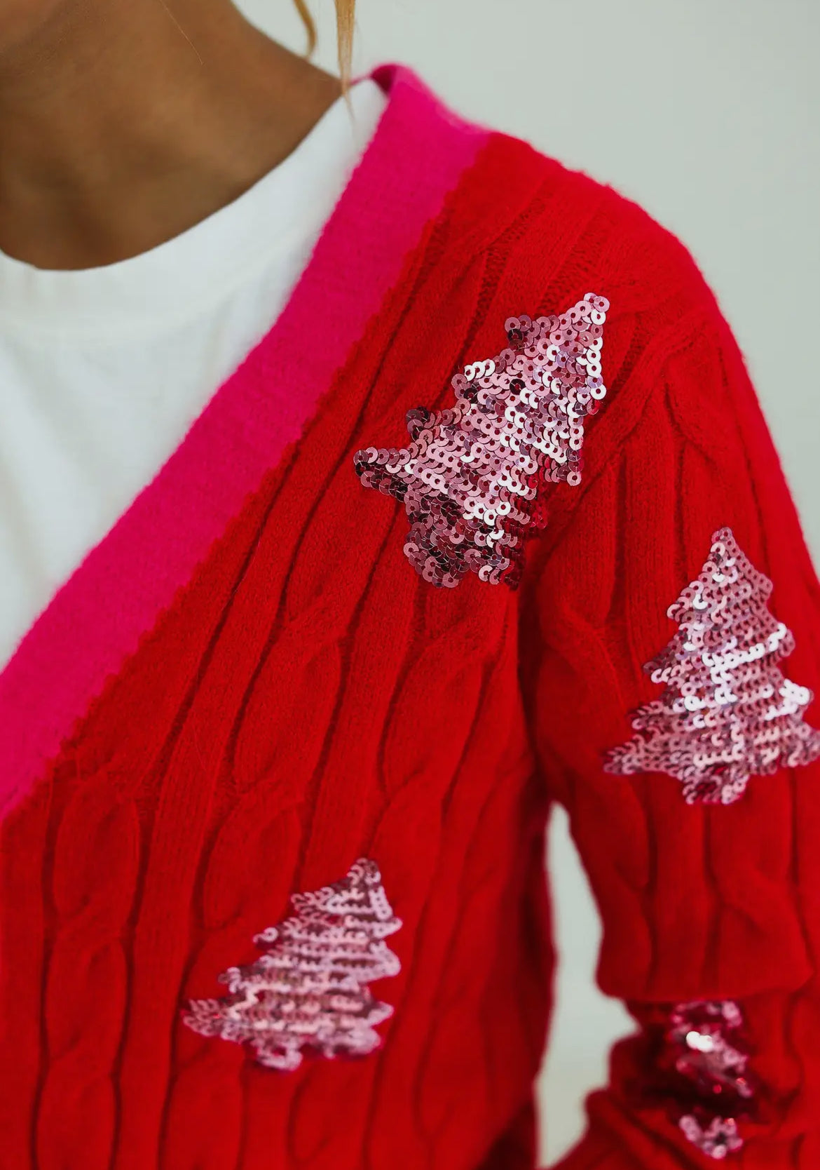 Red sequined xmas tree accented with pink cardigan