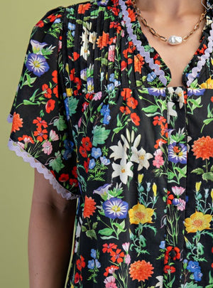 Black floral dress trimmed in lilac ric rac(lined)